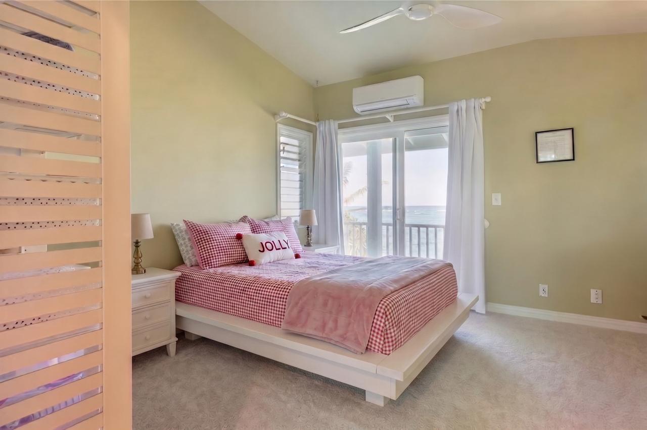 Main House bedroom with pink bedding and balcony doors